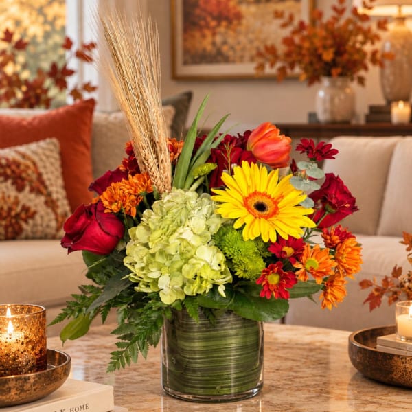 Mixed autumn bouquet in a glass vase with red, orange, yellow, and green flowers