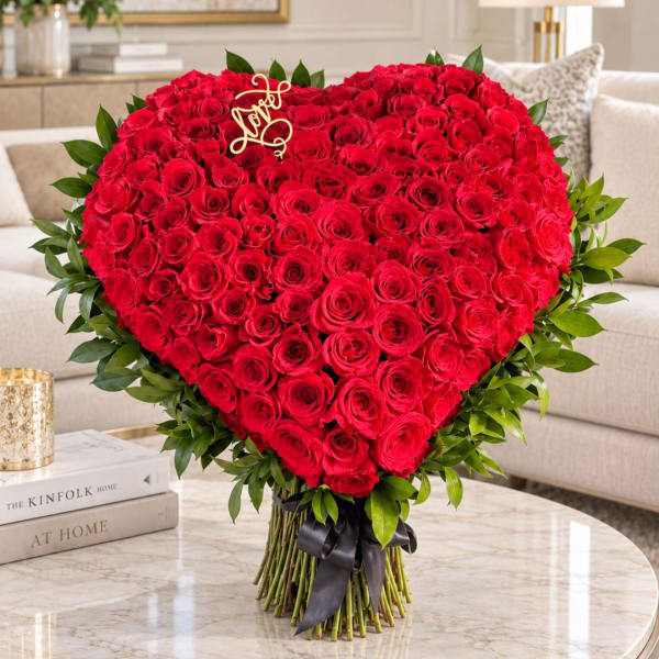 Heart-shaped bouquet of red roses with a gold "Love" topper