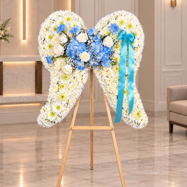 Heart-shaped floral wreath on a wooden easel with blue ribbon