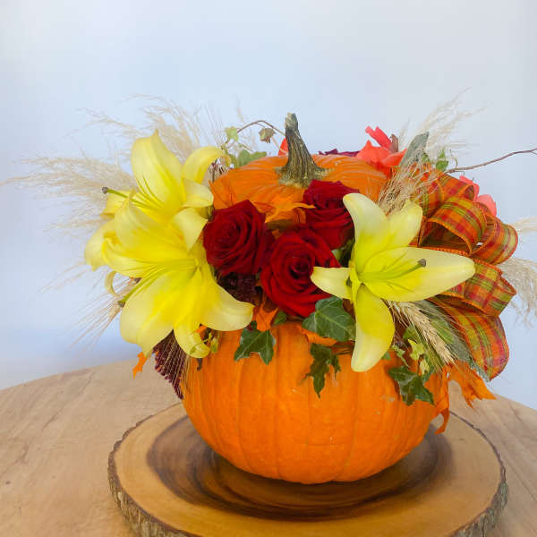 Pumpkin centerpiece with red roses and yellow lilies