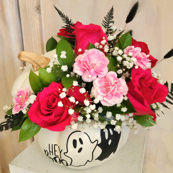 Pink and red rose bouquet with carnations in a white pumpkin vase