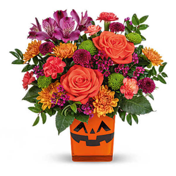 Colorful bouquet in an orange jack-o'-lantern vase