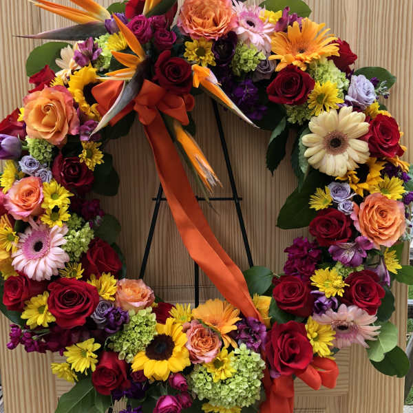 Large floral wreath with roses, gerbera daisies, and bird-of-paradise flowers