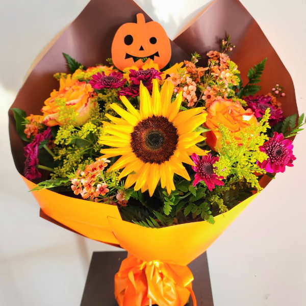 Bouquet with a sunflower, orange roses, and a pumpkin topper