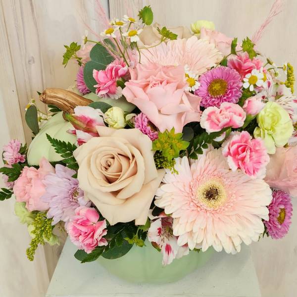 Pastel mixed flower arrangement in a pale green vase