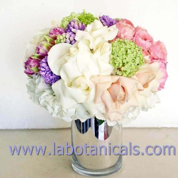 Bouquet of white, pink, and purple flowers in a clear glass vase