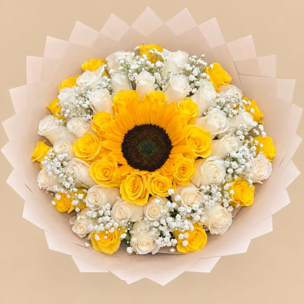 Bouquet of yellow sunflowers and white roses wrapped in pale pink paper