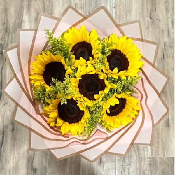 Bouquet of sunflowers wrapped in pale pink paper