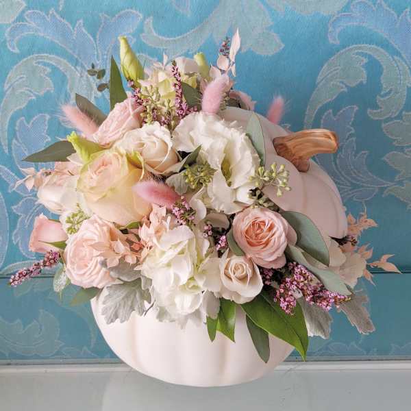 Pastel floral arrangement in a white pumpkin-shaped container
