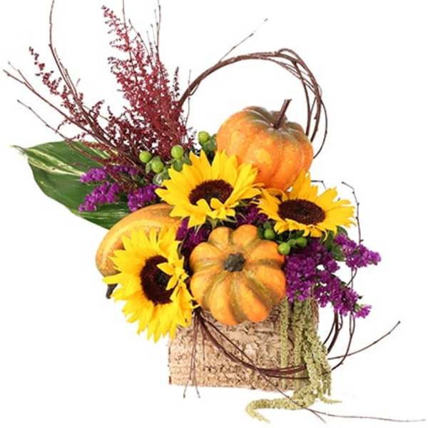 Autumn arrangement with sunflowers and pumpkins in a rustic container
