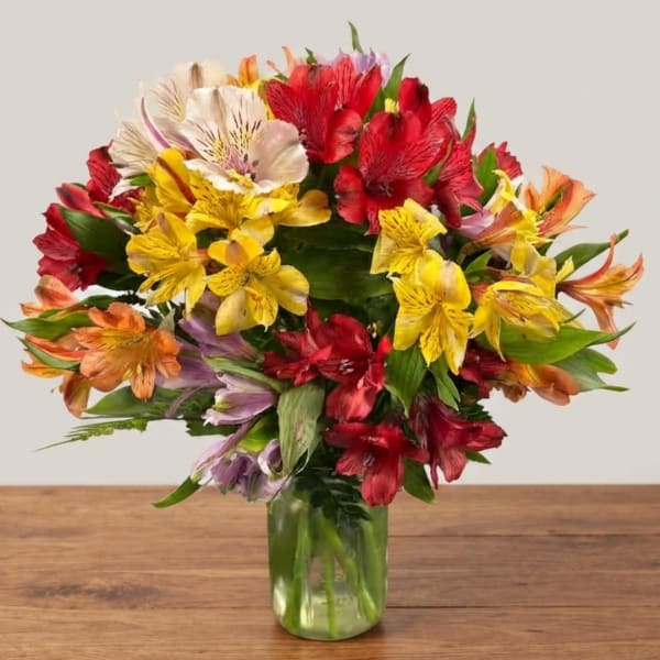 Colorful bouquet of alstroemeria in a clear glass vase