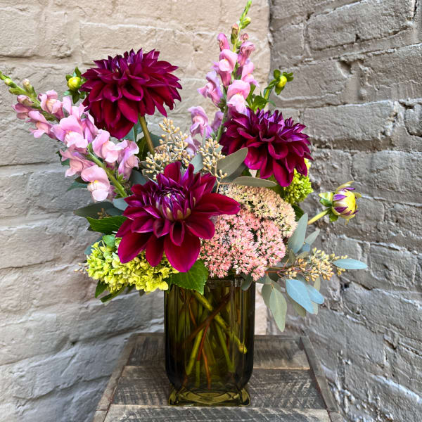 Bouquet of magenta dahlias and pink snapdragons in a glass vase