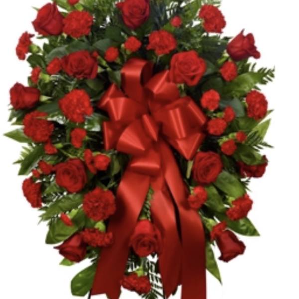 Red rose and carnation standing spray with a large red ribbon