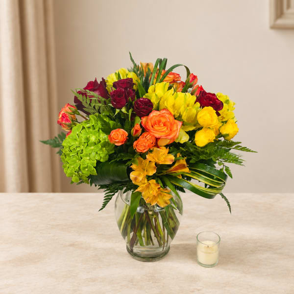 Mixed bouquet of roses, hydrangeas, and alstroemeria in a glass vase