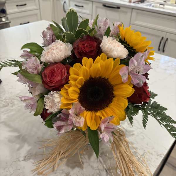 Bouquet with sunflowers, red roses, pink alstroemeria, and carnations