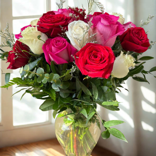 Bouquet of red, pink, and white roses in a clear glass vase