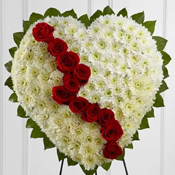 Heart-shaped floral tribute with white chrysanthemums and red roses
