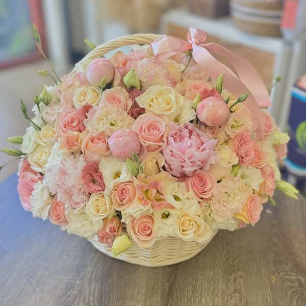 Basket of pink and cream roses with peonies and ribbon