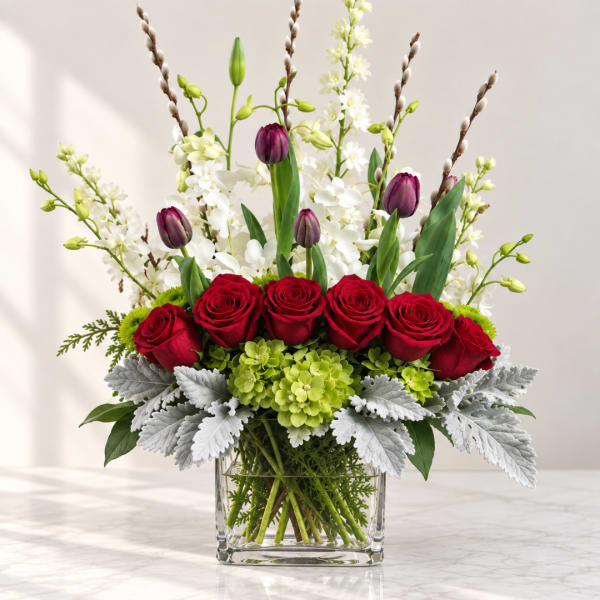 Red roses and purple tulips in a clear square vase