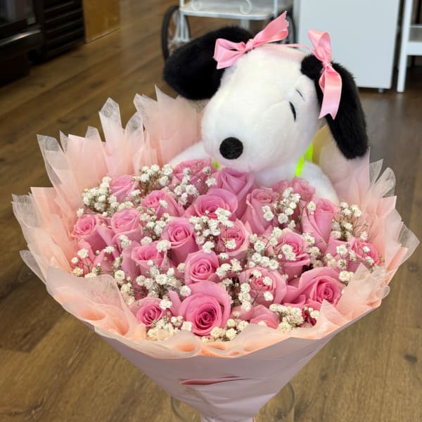 Pink rose bouquet with baby's breath and a Snoopy plush topper