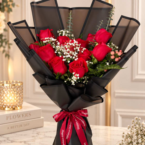 Bouquet of red roses wrapped in black paper with a red ribbon