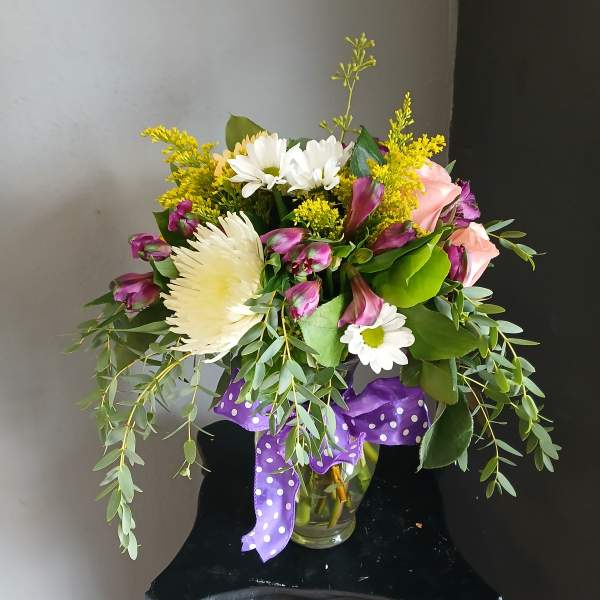 Mixed bouquet in a glass vase with white, pink, and yellow flowers