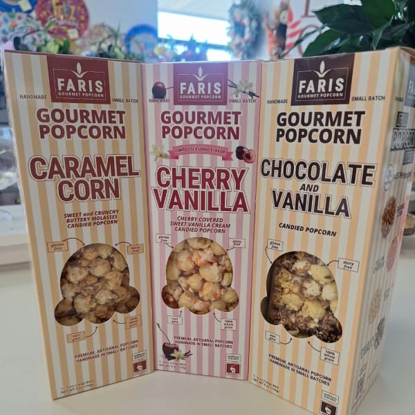 Three boxes of gourmet popcorn in caramel, cherry vanilla, and chocolate vanilla flavors