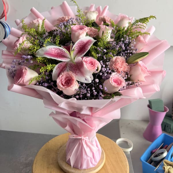 Pink bouquet with roses, lilies, and carnations wrapped in pink paper