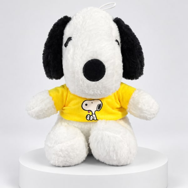 Snoopy plush toy wearing a yellow shirt on a white pedestal