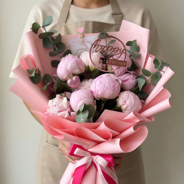 Pink peony bouquet with eucalyptus and a birthday topper