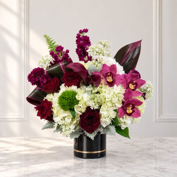 Bouquet of burgundy and pink flowers in a black vase