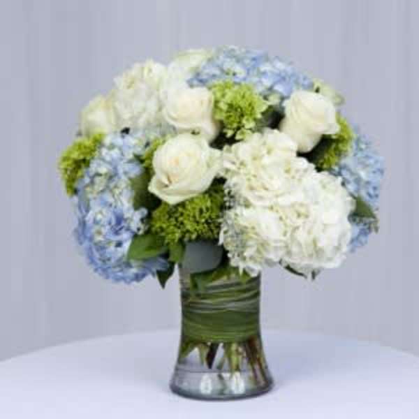 White and blue floral arrangement in a glass vase