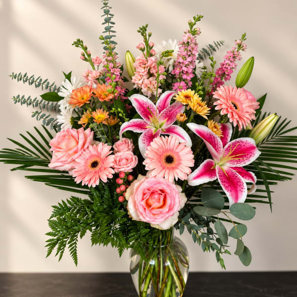 Pink and white mixed flower arrangement in a clear glass vase