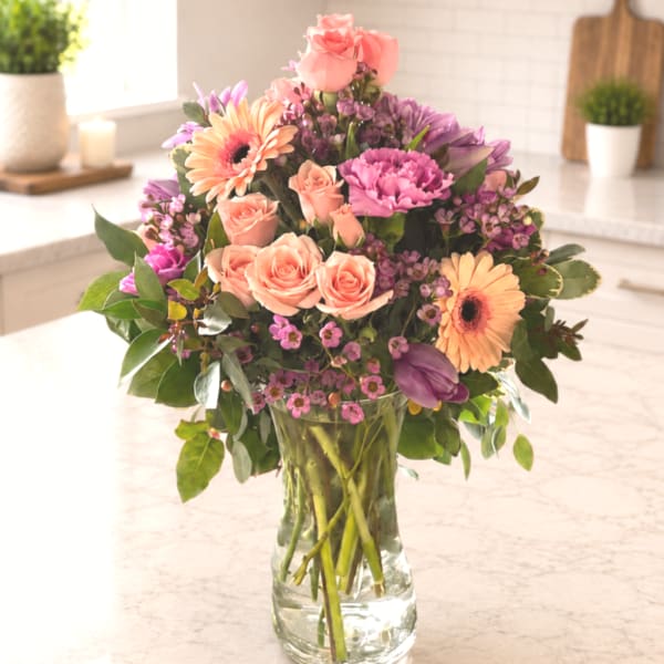 Mixed pink and purple bouquet in a clear glass vase