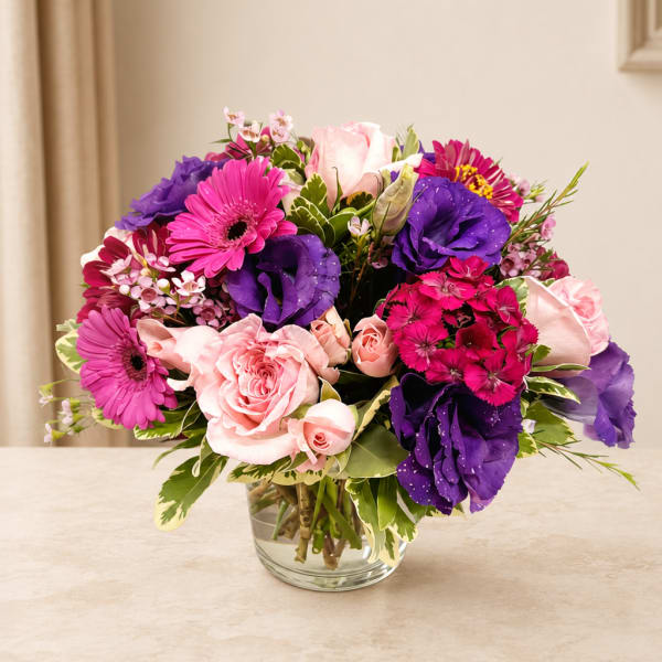 Pink and purple mixed bouquet in a clear glass vase