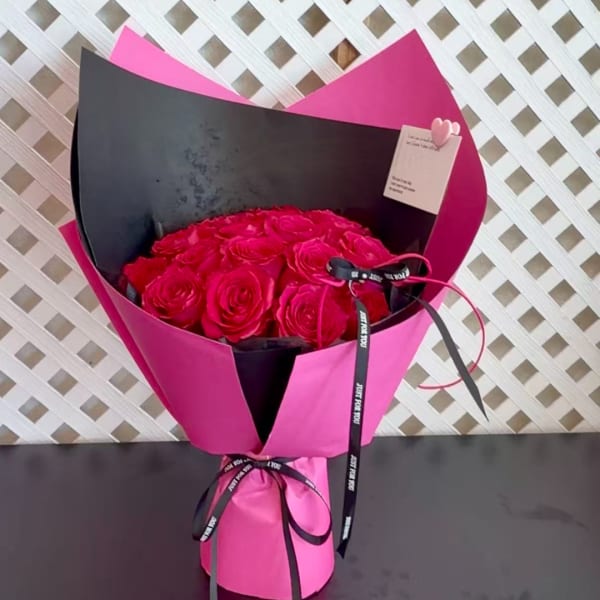 Bouquet of hot pink roses wrapped in black and pink paper