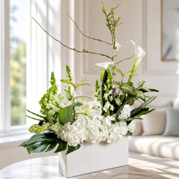 White floral arrangement in a rectangular vase with tall branching stems