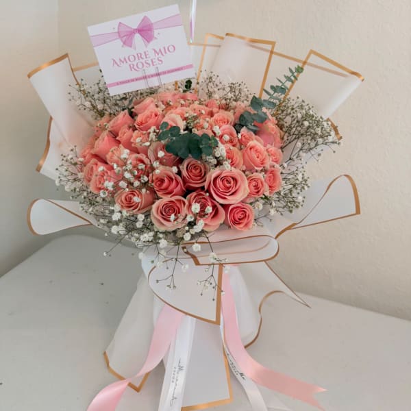 Bouquet of pink roses with baby's breath and ribbon wrapping