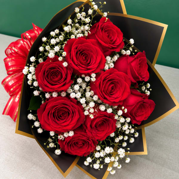 Bouquet of red roses with white baby's breath in black and gold wrap