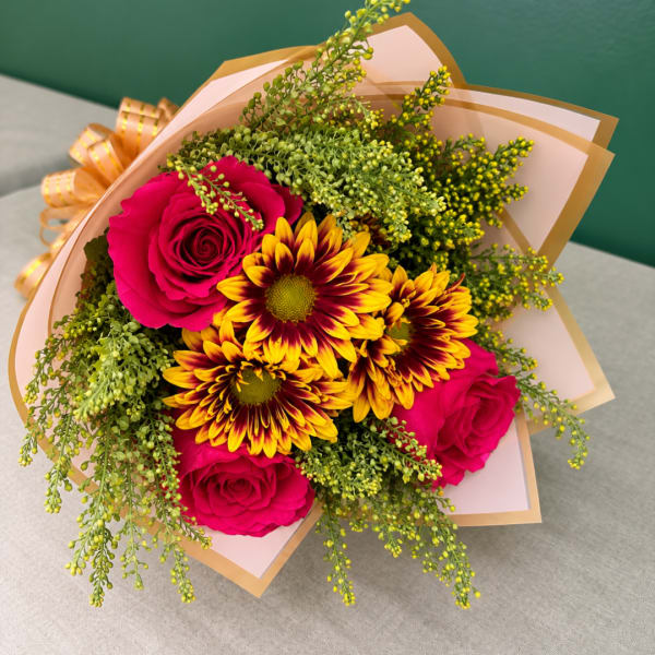 Bouquet of hot pink roses and yellow-red chrysanthemums wrapped in pink paper