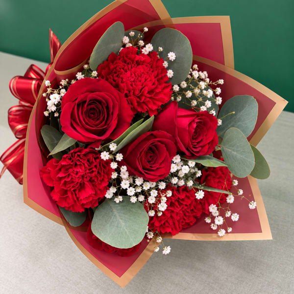 Bouquet of red roses and carnations with white filler flowers