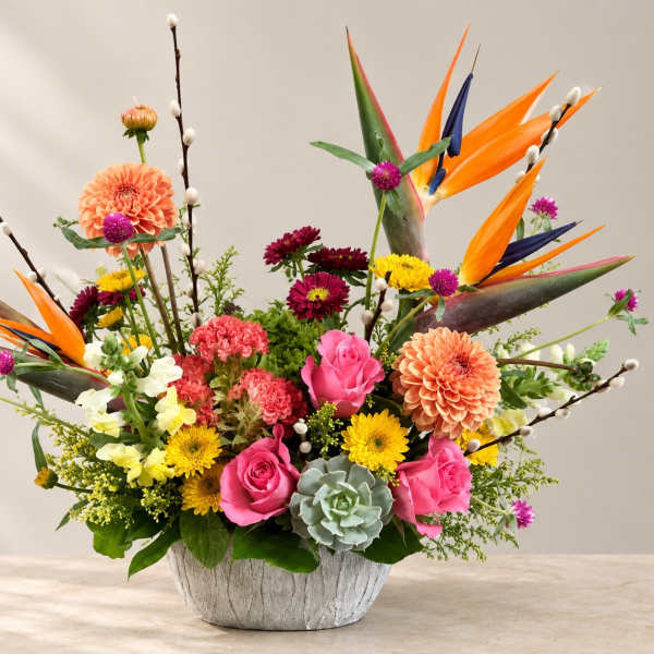Colorful mixed flower arrangement in a white textured bowl vase