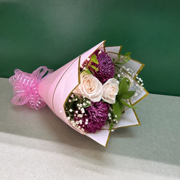 Pink-wrapped bouquet with white roses and purple chrysanthemums