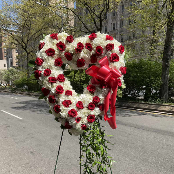 Heart-shaped red and white floral standing arrangement with ribbon