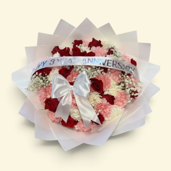 Red roses and pink carnations wrapped with a silver anniversary ribbon