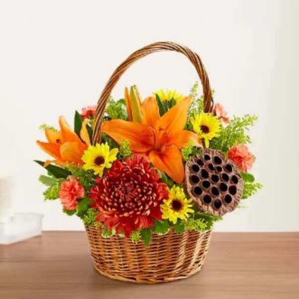 Basket arrangement with orange lilies, yellow daisies, and red chrysanthemums