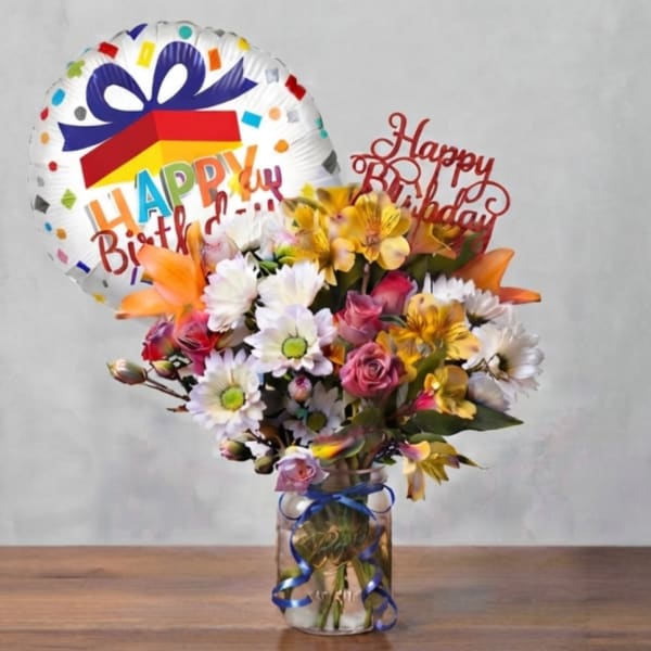 Birthday bouquet in a glass jar with a foil balloon and flower picks