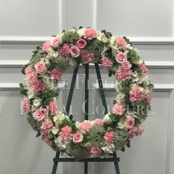 Pink and white floral wreath on a dark easel