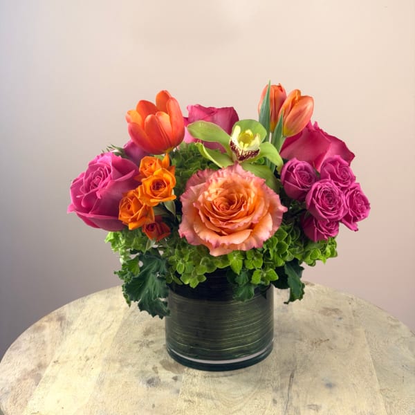 Colorful bouquet of roses and tulips in a glass vase