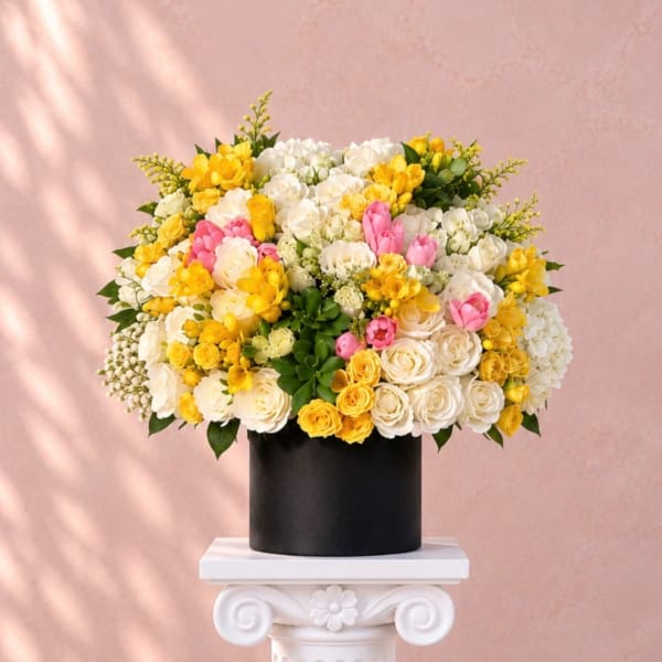Yellow, white, and pink flowers arranged in a black vase